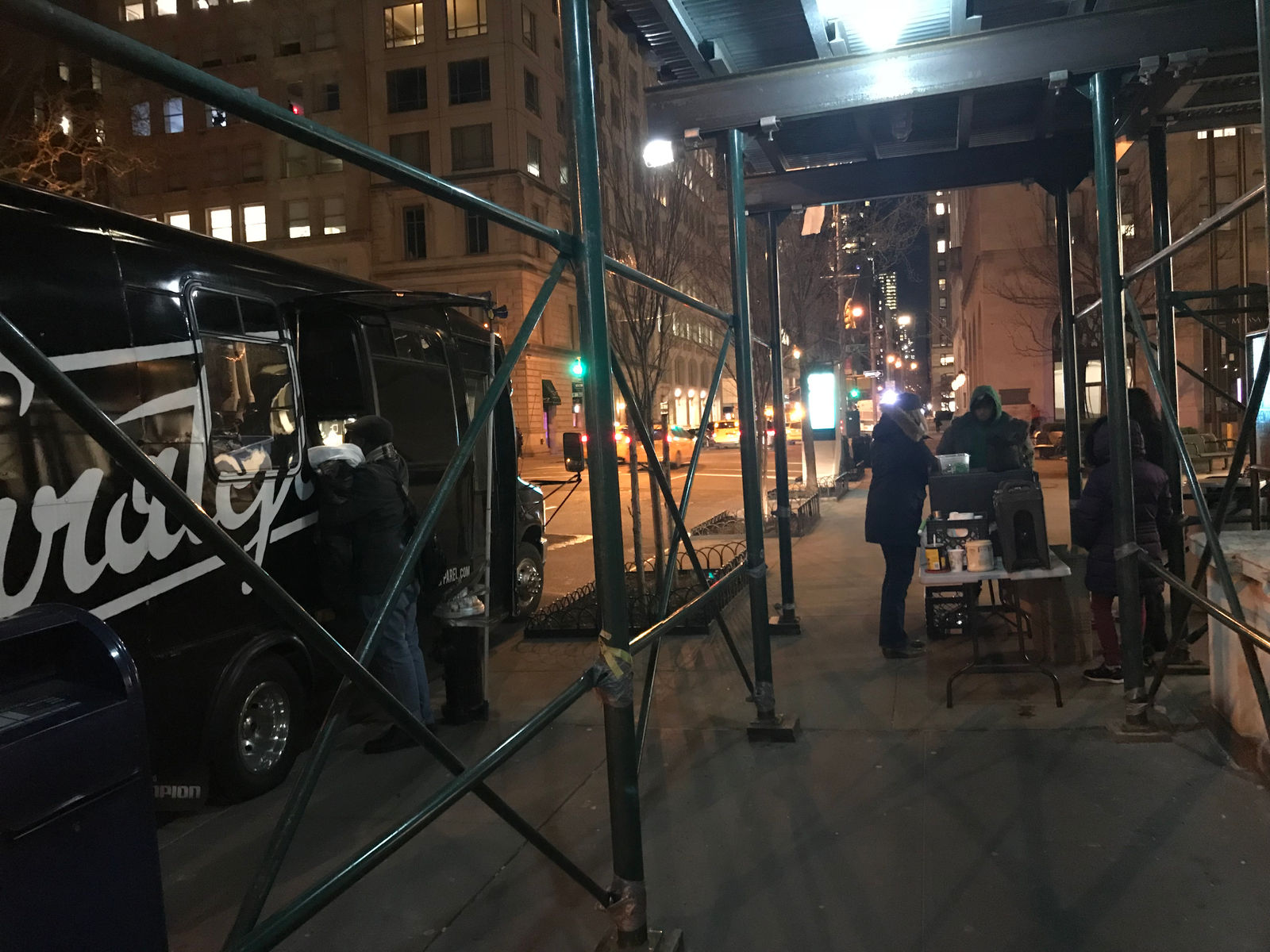 Hot drinks and supplies set up under scaffolding at night